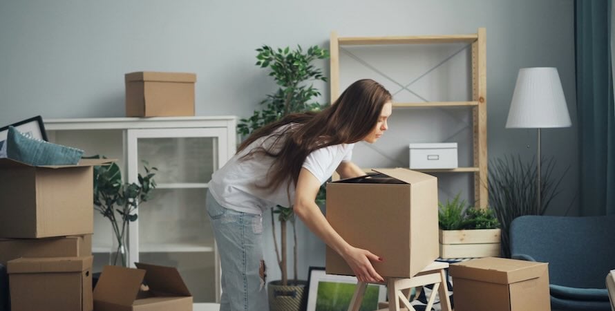 young woman unpacking boxes in house