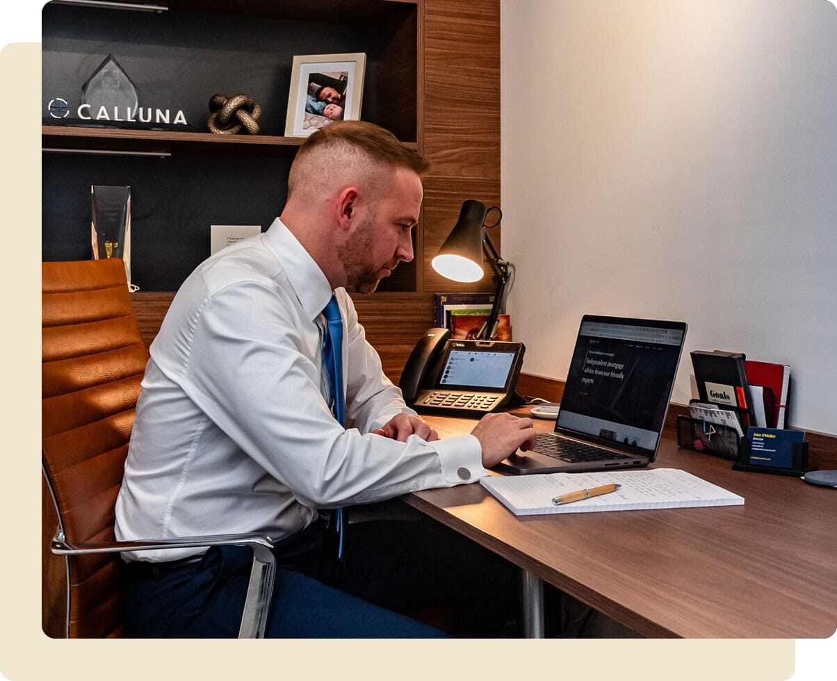 John O'Malley working at his desk with his laptop